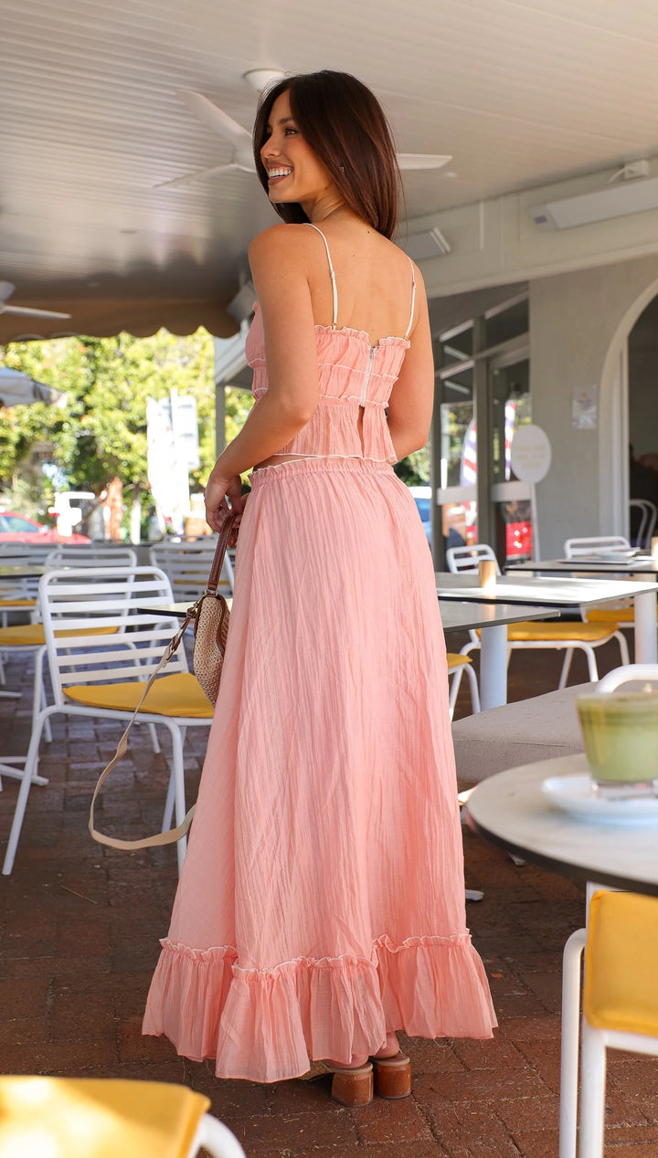 Pink ruffled maxi dress with ties, made of lightweight chiffon. Features a flowy design with delicate ruffles for a feminine…