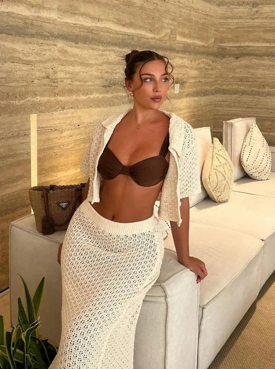 "Two-piece matching set with crochet top and skirt in off-white color, featuring intricate lace design and a flattering…