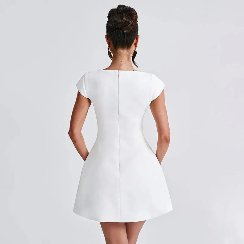 White mini dress with a square neckline, showcasing elegant design and refined simplicity.