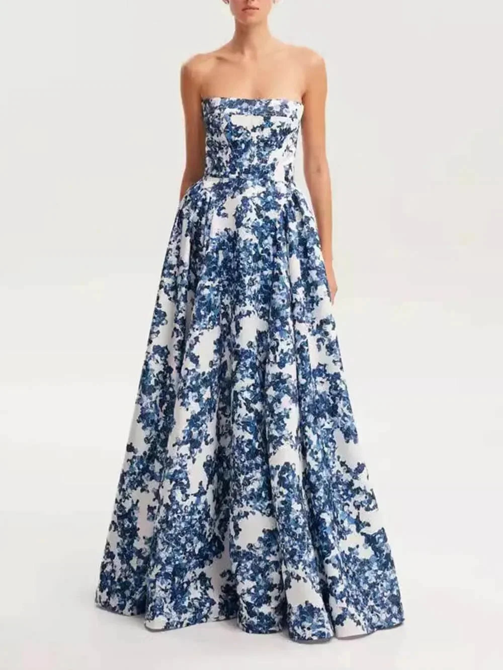 Strapless blue floral printed maxi dress made from lightweight fabric with a flowy silhouette and vibrant floral pattern.