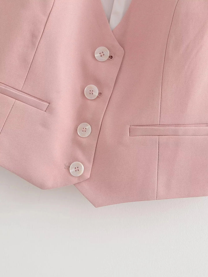 Soft pink V-neck vest with button details, made of cozy knitted fabric, perfect for layering in casual and comfortable style.