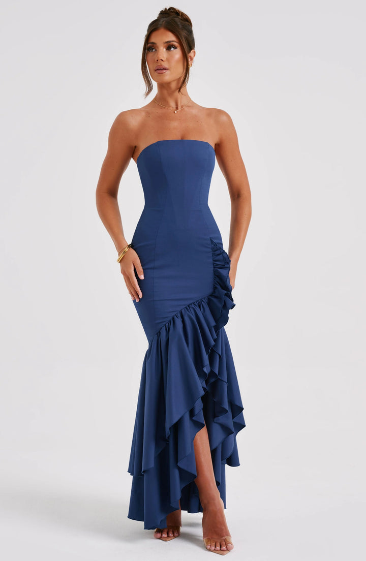 Strapless dress in sage green with ruffle skirt cascading from waist to knee. Made of lightweight, flowy fabric.