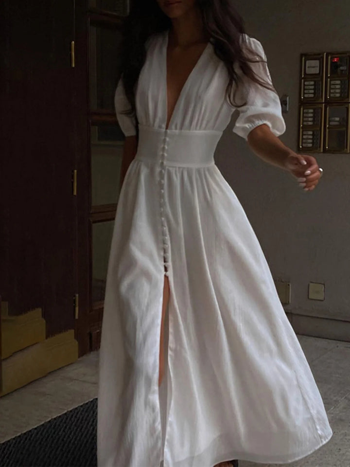White shirt dress with fitted waist, front slit, and button detailing. Made from lightweight and breathable fabric for a…