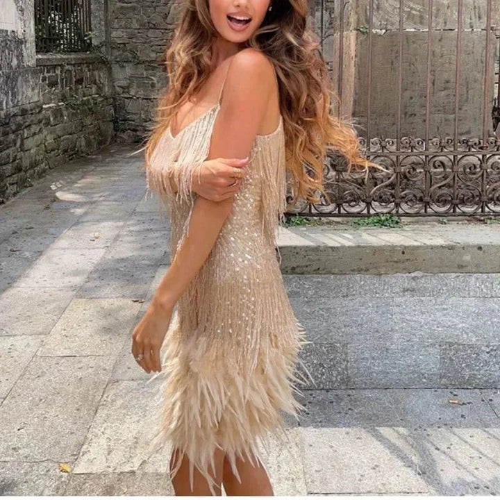 "Black mini dress with spaghetti straps, sequins, and feather trim, perfect for night outs or special occasions."