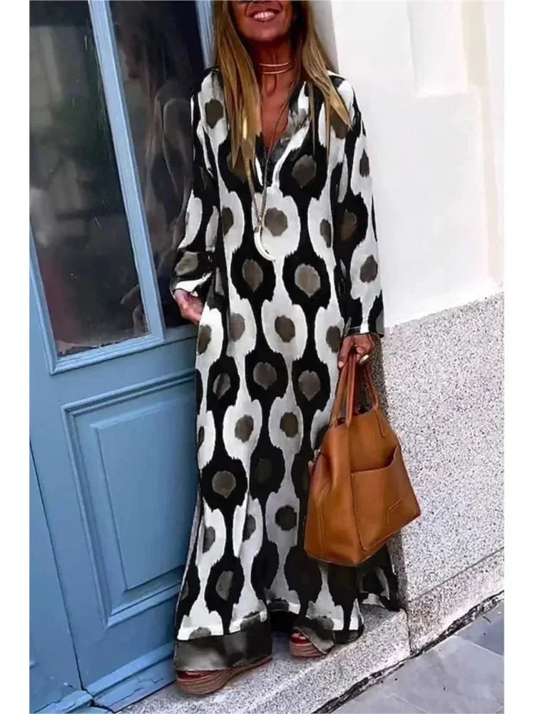 Black V-neck maxi dress featuring a long-sleeve design. Made of soft and flowy fabric with a flattering silhouette.