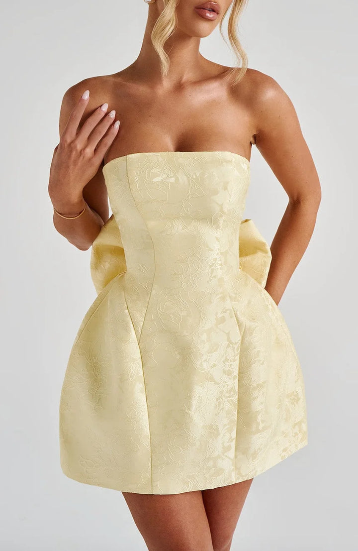 Strapless mini dress in candy color with oversized bow detail. Perfect for a fun and flirty look at your upcoming event.