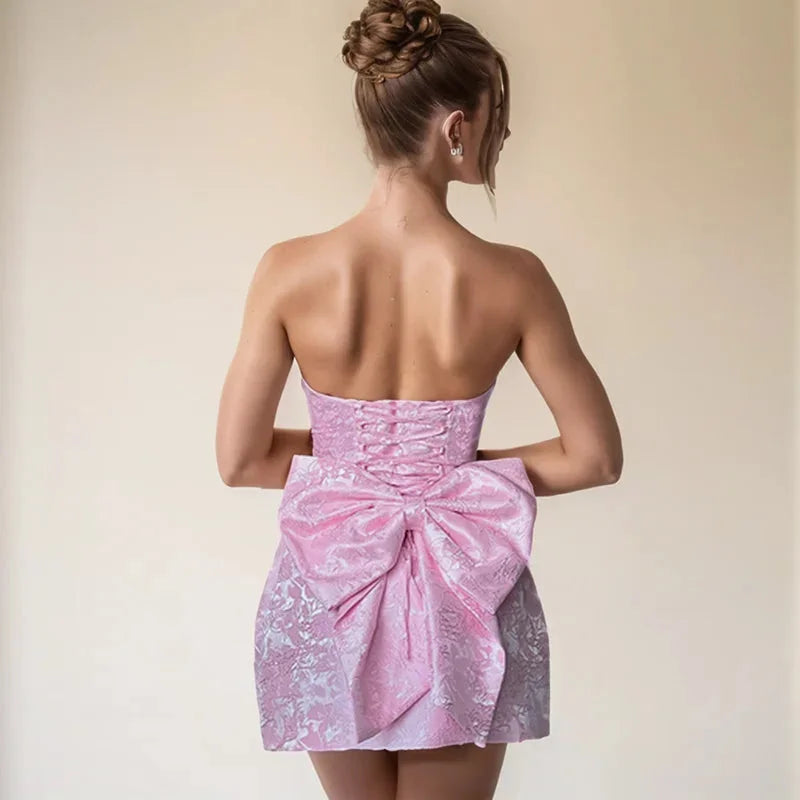 Pink strapless mini dress with oversized bow detail. Made of soft cotton fabric with a stylish design, perfect for a fun and…