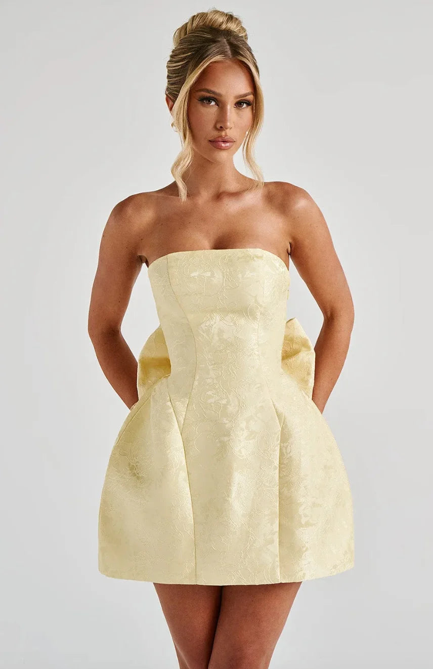 Yellow strapless mini dress with oversized bow detail, perfect for a fun and flirty look.