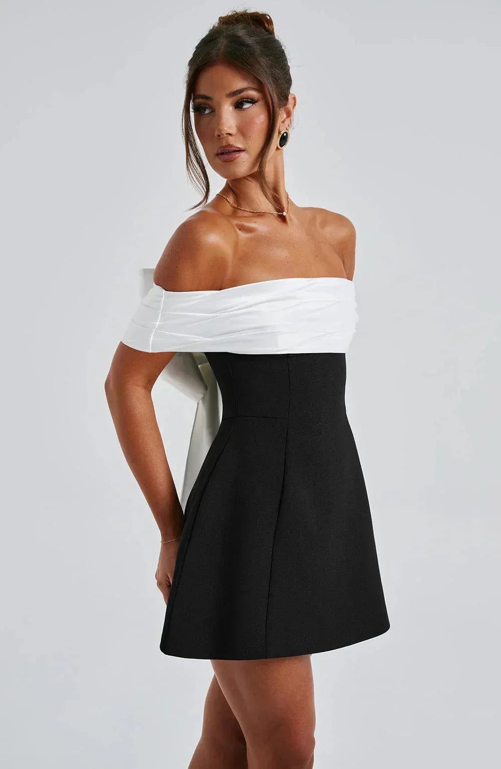 Off-shoulder mini dress in two-tone design, made from soft cotton blend with elegant pleated details.