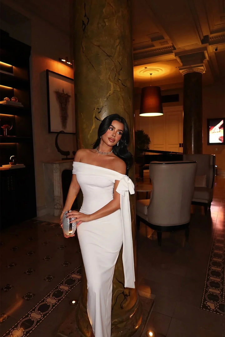 White maxi dress with a flattering fit, V-neckline, and flowy design. Ideal for any occasion.