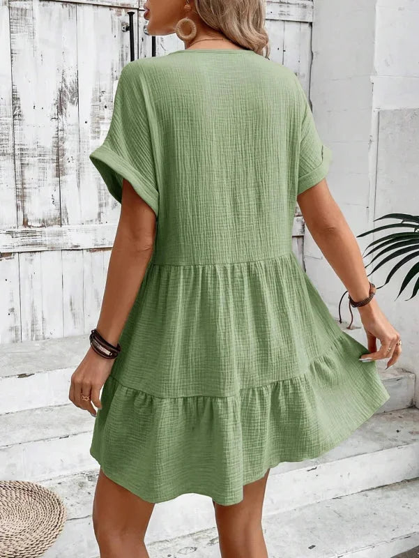 "Vibrant floral v-neck dress with cascading ruffled layers, perfect for summer, made of lightweight and breathable fabric."