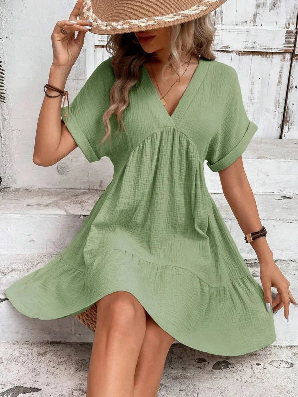"Black flowy v-neck dress featuring ruffled layers, perfect for a stylish and elegant look at any event."