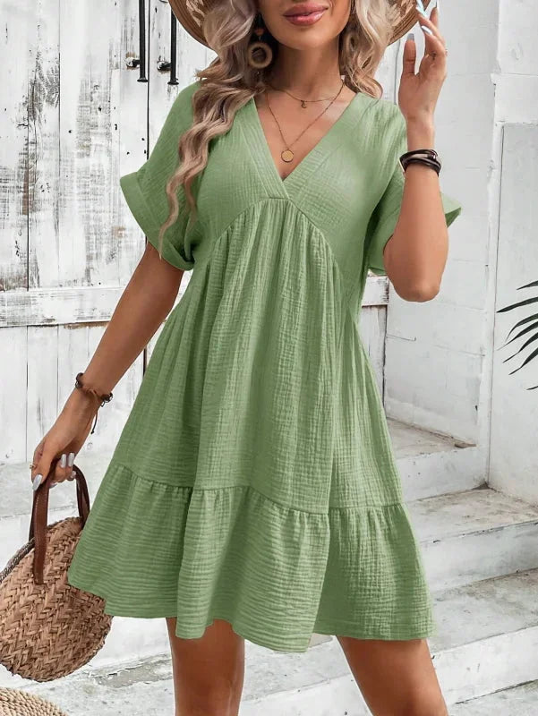 Green Cattleya dress with ruffled layers, made of flowy and lightweight fabric, features a flattering v-neck design.