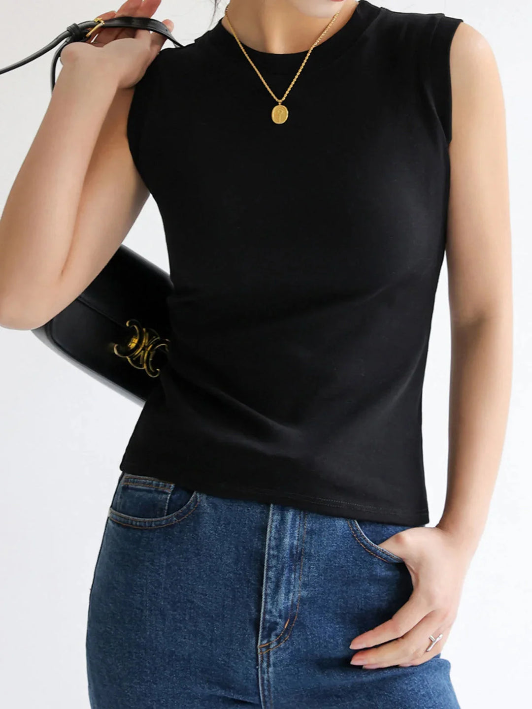 Sleeveless fitted top in soft cotton blend with V-neck and asymmetrical hem, perfect for layering or standalone wear.