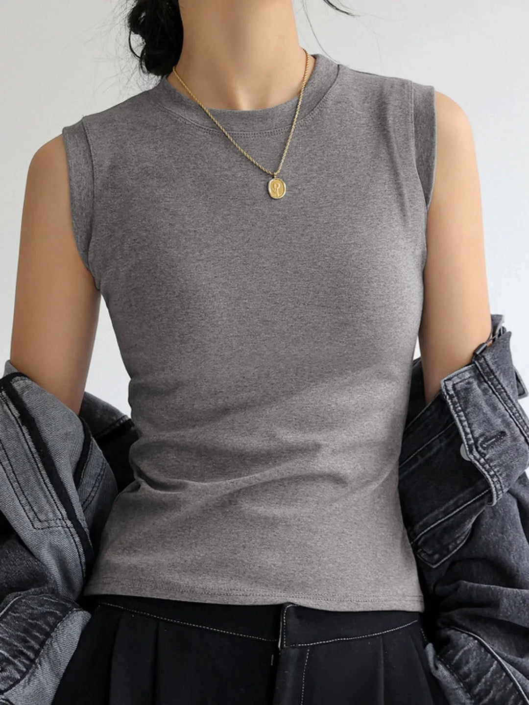 Black sleeveless top with V-neck design and ribbed texture. Versatile and fitted for contemporary style.