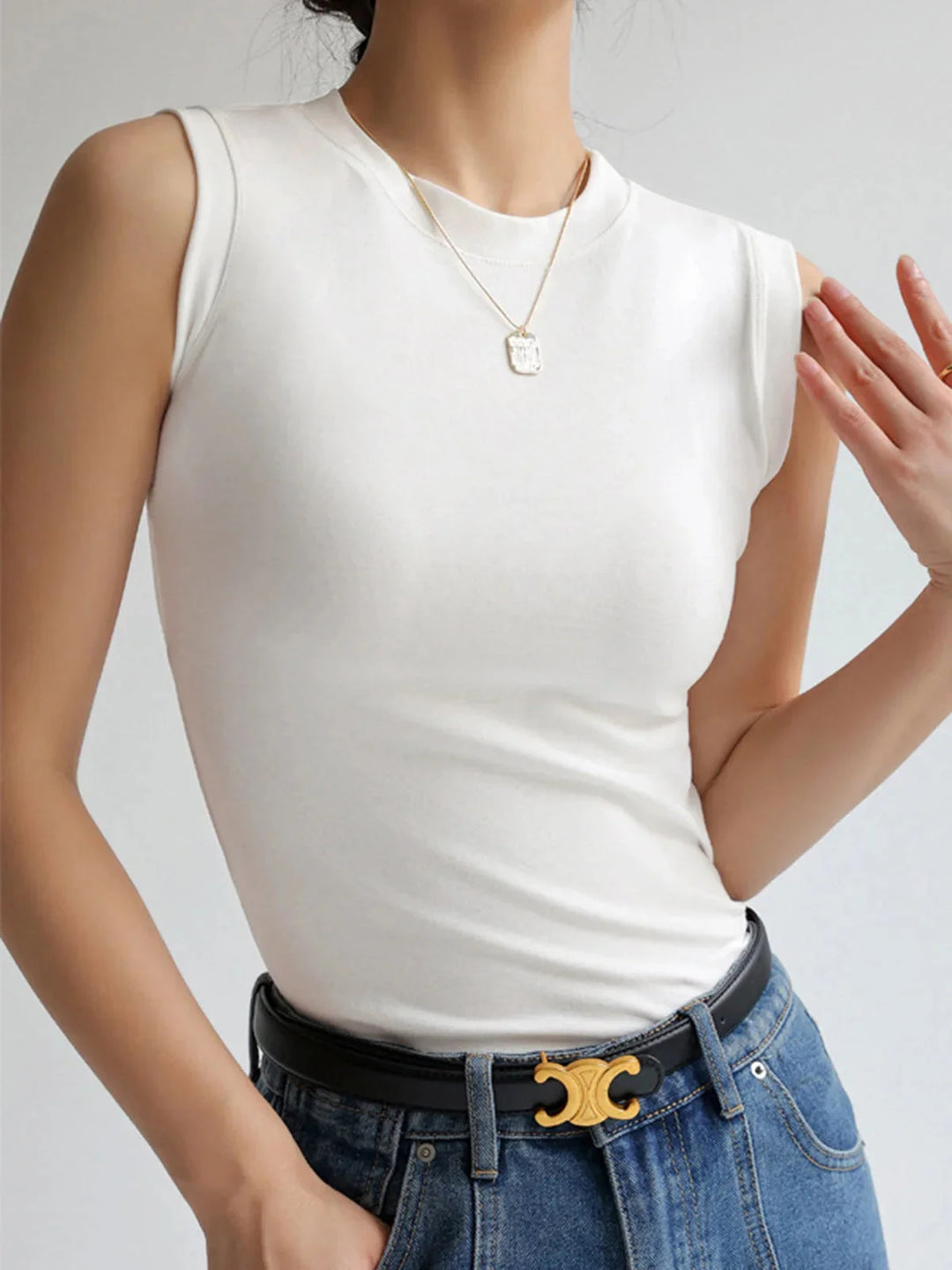 White sleeveless top crafted from soft cotton blend with a chic fitted design, ideal for versatile styling in the Cheyenne…