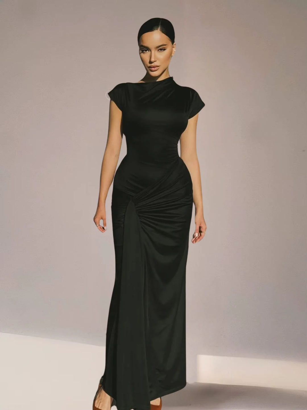 "Black maxi dress with ruched detailing, capped sleeves, and flowing silhouette, perfect for a stylish and elegant look."