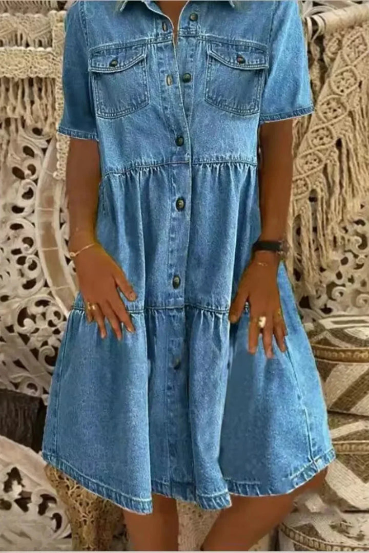Dark blue denim dress with short sleeves and functional pockets. Casual and stylish design perfect for everyday wear.