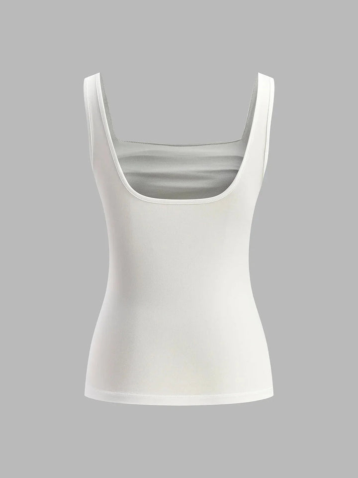 "Sleeveless ruched top in coral color. Versatile design, perfect for layering or worn alone for a chic look."