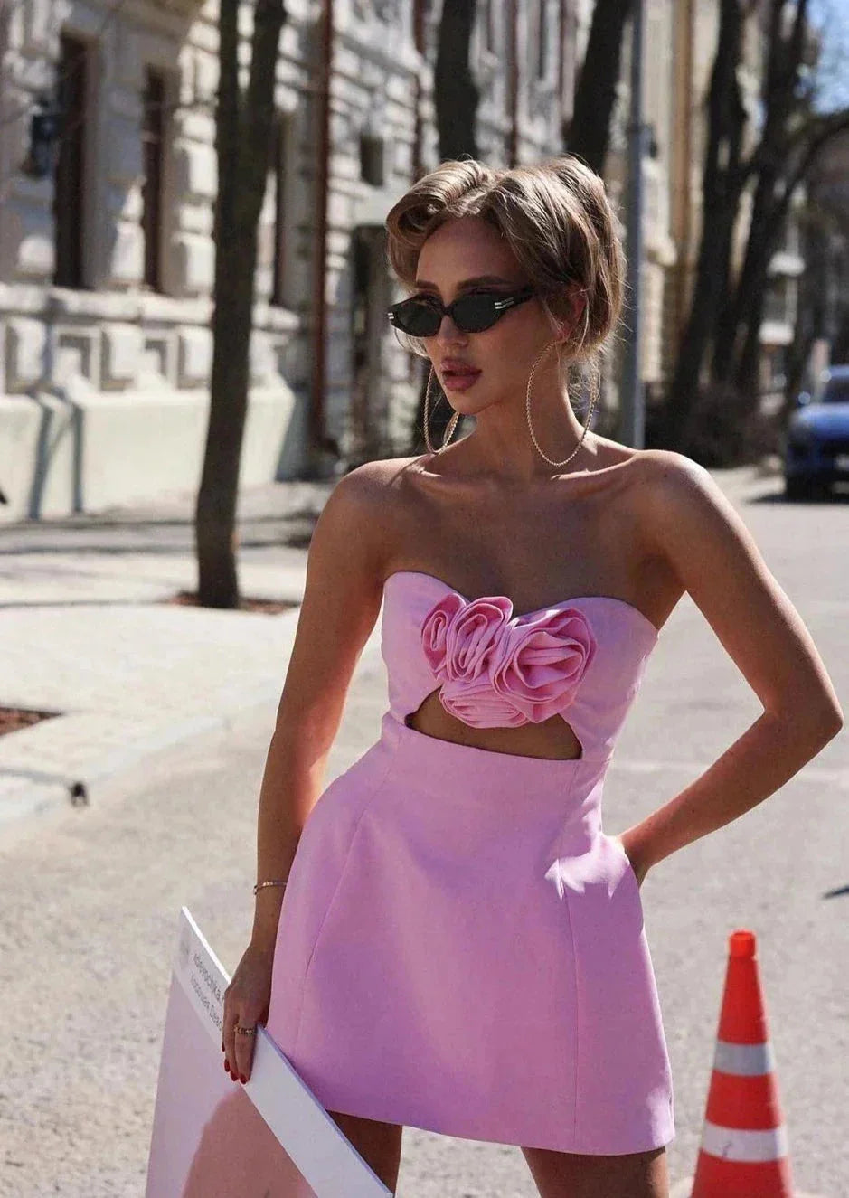 Strapless pink mini dress adorned with floral accent, perfect for a romantic evening.