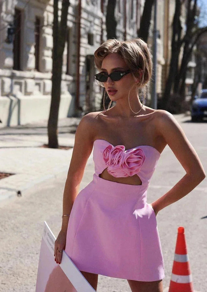 Strapless pink mini dress adorned with floral accent, perfect for a romantic evening.