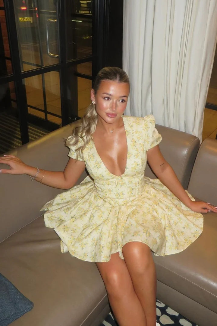 "Yellow floral dress with back tie, made of lightweight and airy fabric, perfect for a sunny day out."