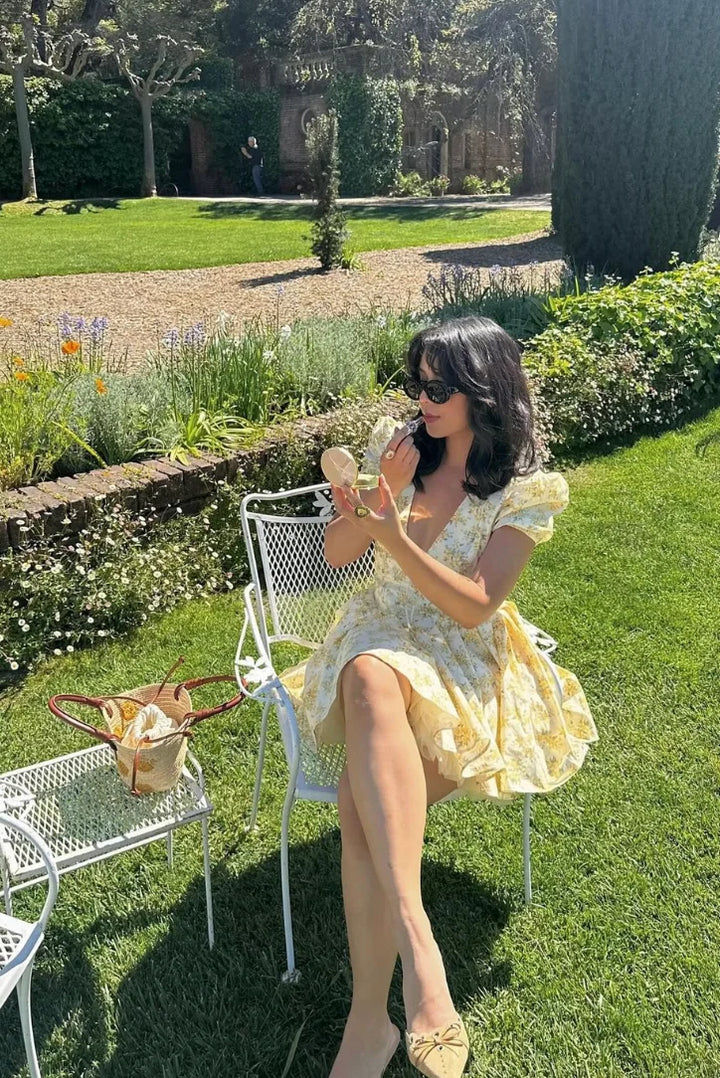 Yellow floral dress with back tie, made with soft, flowy fabric. Features a vibrant print with a flattering silhouette.