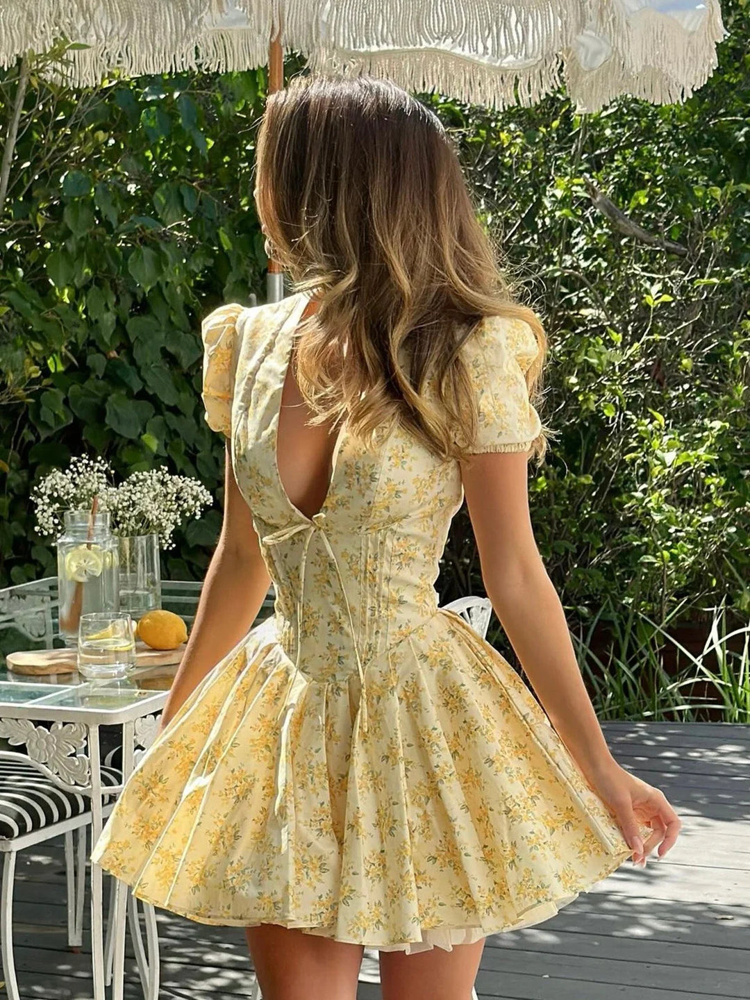 Yellow floral dress with back tie, featuring a dainty floral print on light fabric. Feminine design perfect for sunny days…
