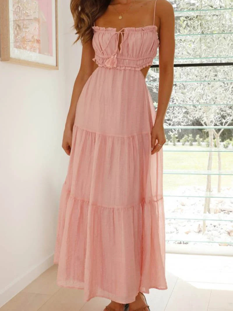 Pink tiered maxi dress with drawstring detail, made of flowy fabric. Perfect for a breezy summer day or a casual night out.