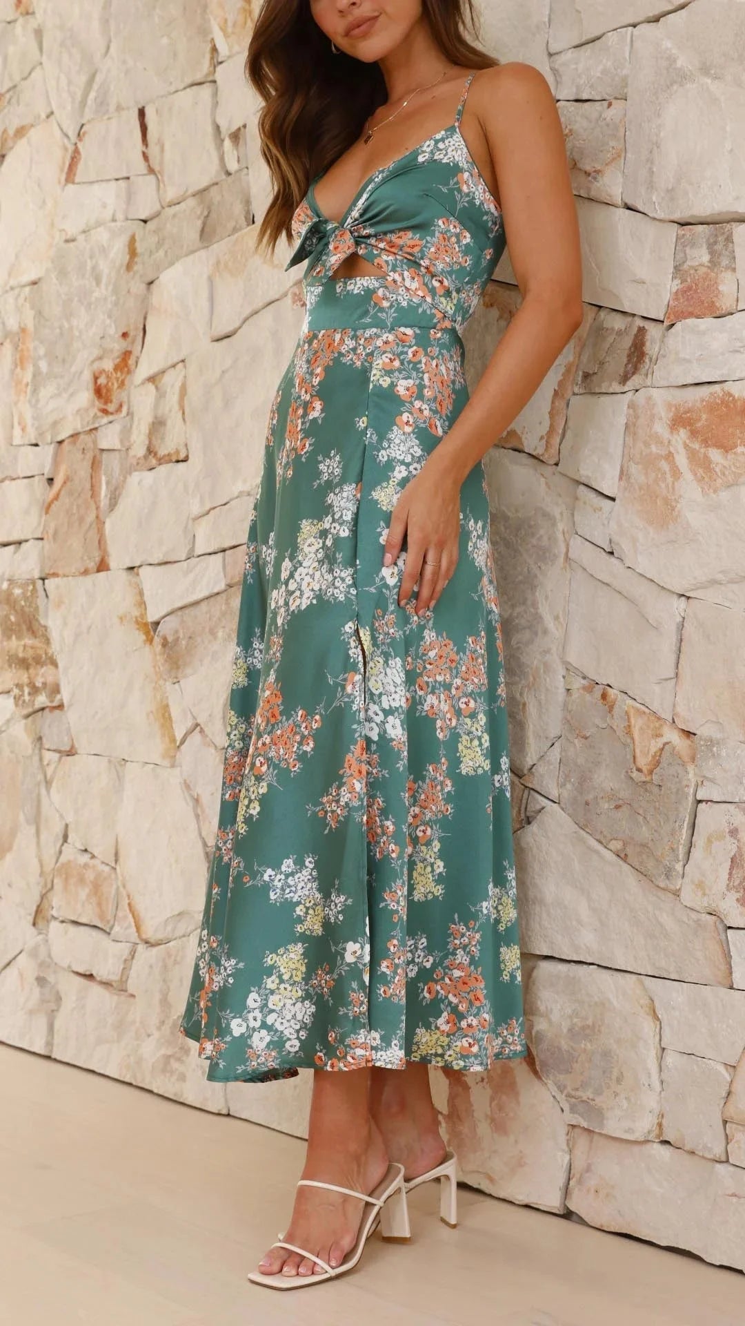 Teal satin dress with a floral print pattern, featuring a front tie detail.
