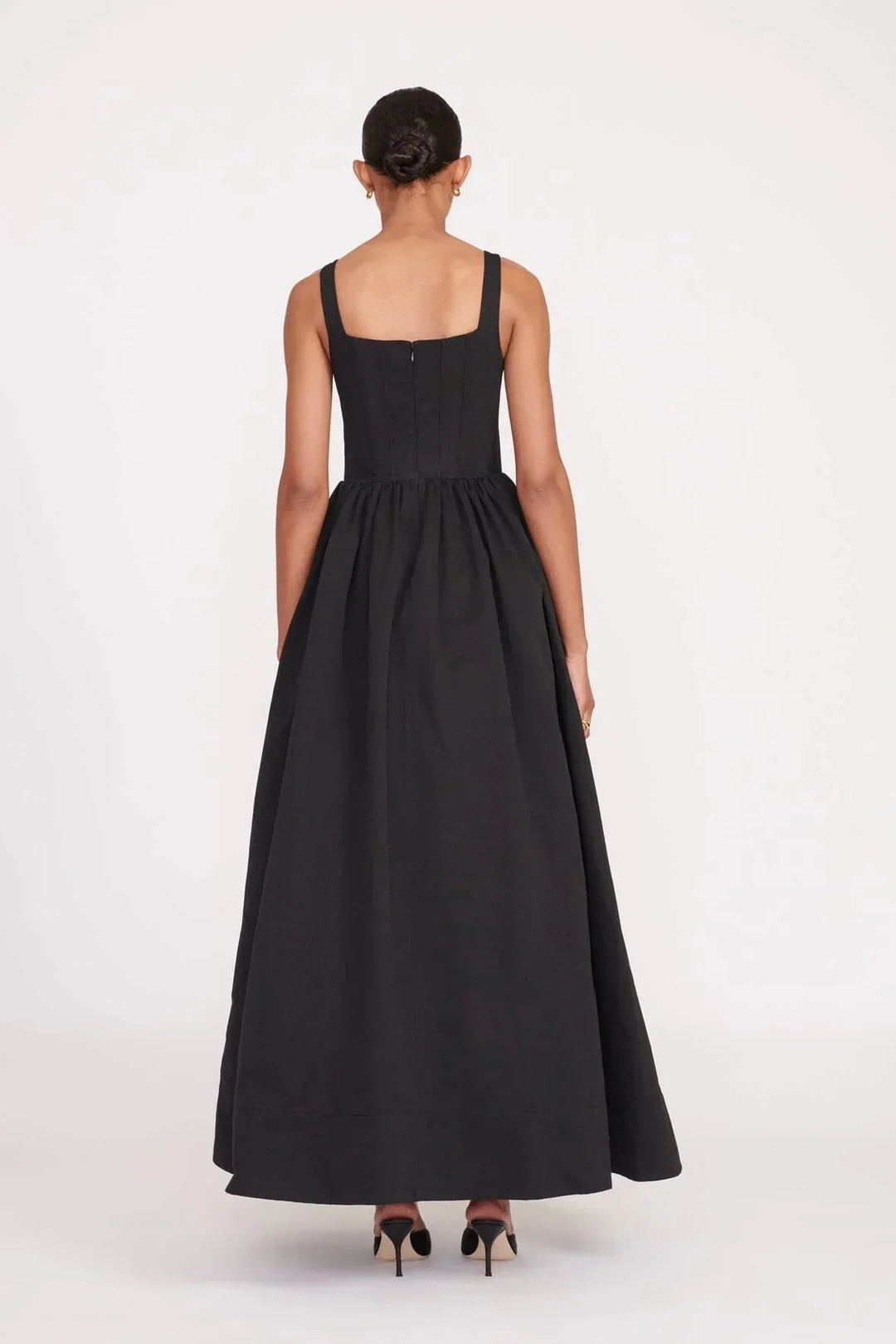 Black square neckline midi dress in a sleeveless style by Devon. Versatile and elegant with a stylish design and timeless…