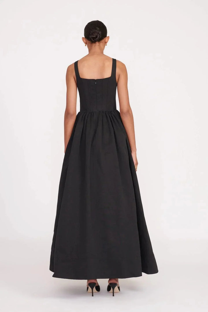 Black square neckline midi dress in a sleeveless style by Devon. Versatile and elegant with a stylish design and timeless…