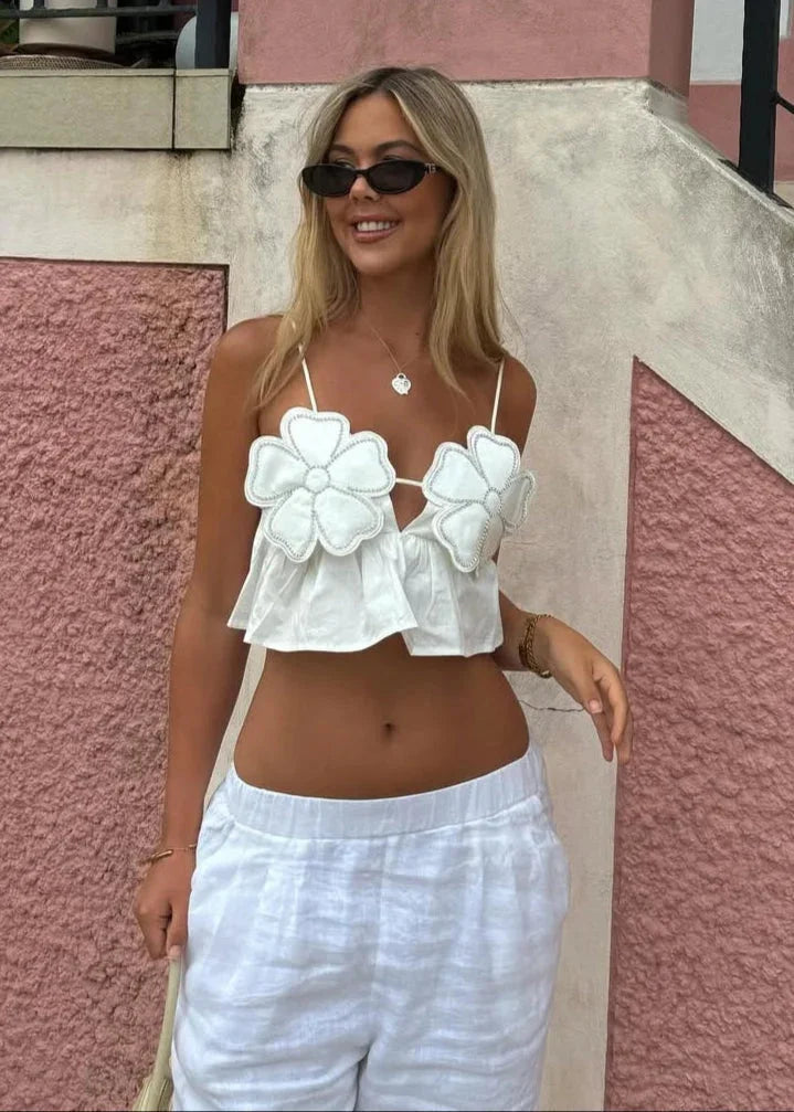 White women's crop top with floral applique design, perfect for summer.