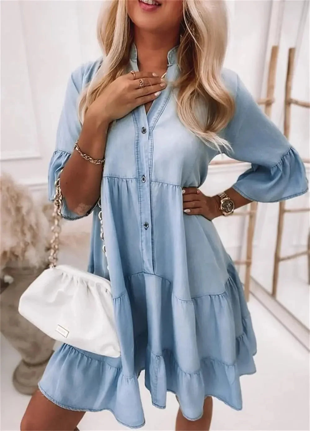 Light blue tiered denim dress with a flowing design, perfect for a casual chic look.