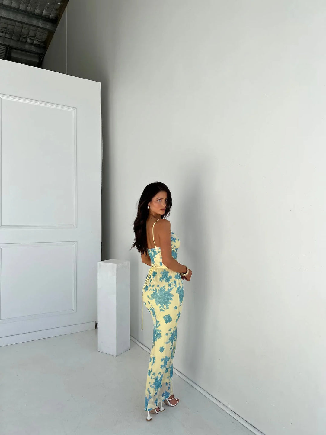 Sleeveless yellow slim-fit maxi dress made from soft cotton with a V-neckline and pleated skirt.