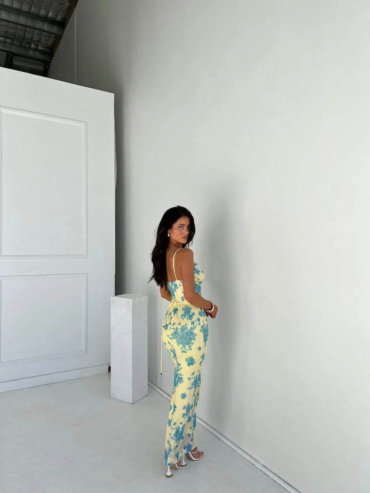 Sleeveless yellow slim-fit maxi dress made from soft cotton with a V-neckline and pleated skirt.