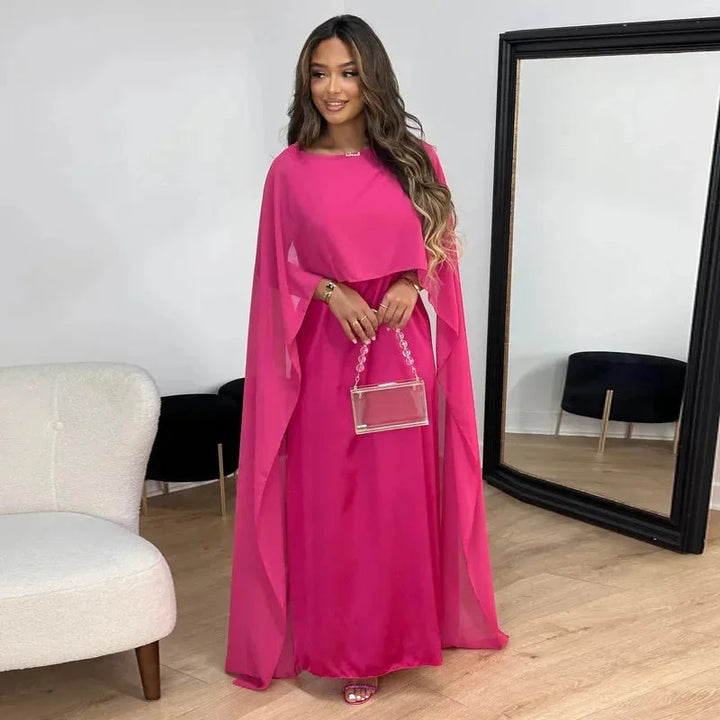 Pink cape maxi dress with a flowy silhouette, perfect for evening wear. Made from soft and comfortable fabric with exquisite…