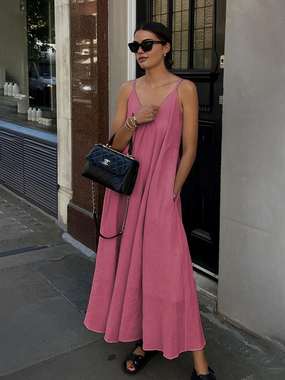 Pink flowy layered maxi dress with V-neck made of soft, airy fabric. Drapes elegantly, perfect for a chic summer look.