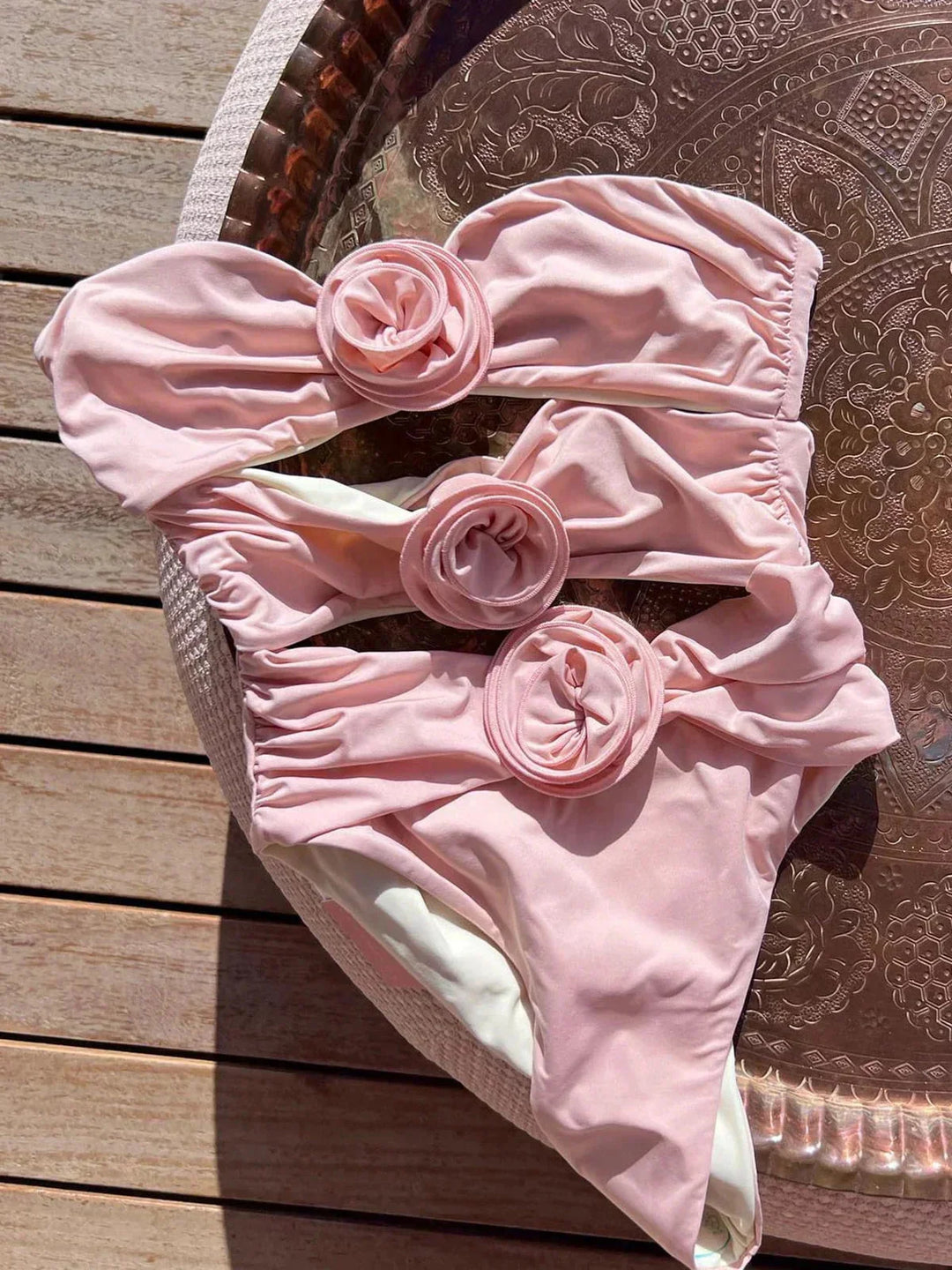 Pink form-fitting strapless swimsuit for women by Gabby, featuring a sleek design and made from high-quality stretch…