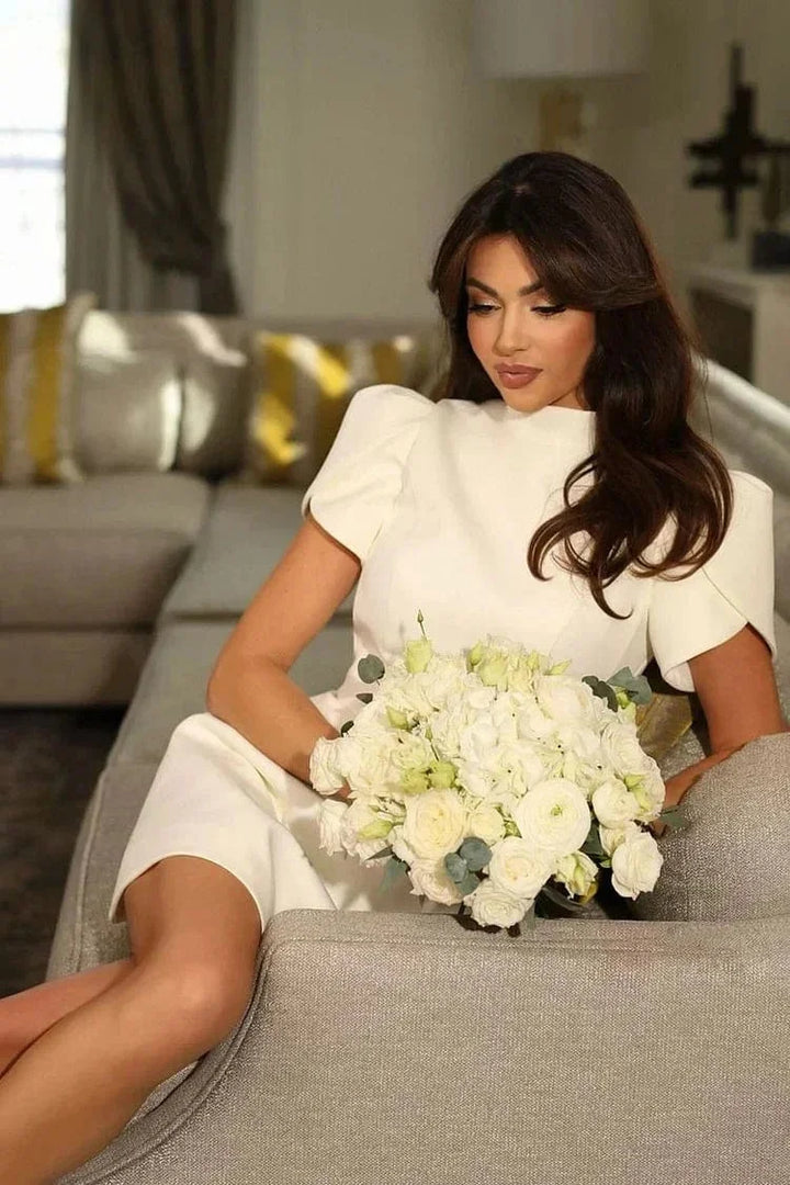 White mini dress with structured ruffled sleeves, perfect for a chic look.