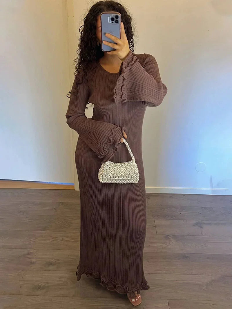 Brown floor-length pleated dress with bell sleeves, perfect for elegant occasions. Feminine and stylish with a flowing…