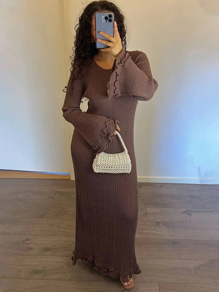 Brown floor-length pleated dress with bell sleeves, perfect for elegant occasions. Feminine and stylish with a flowing…