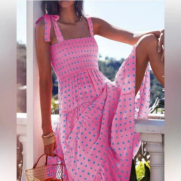 Pink smocked maxi dress with tie straps perfect for summer days. Featuring a soft cotton blend and a flattering smocked…