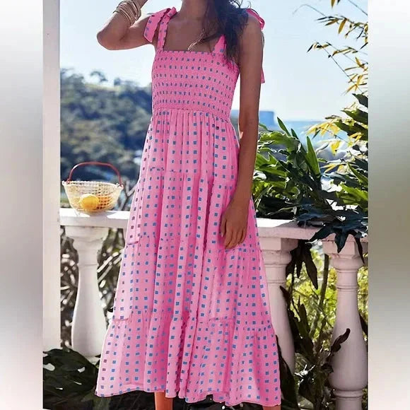 Pink smocked maxi dress with tie straps, perfect for a chic summer look. Features a flattering design and comfortable fabric…