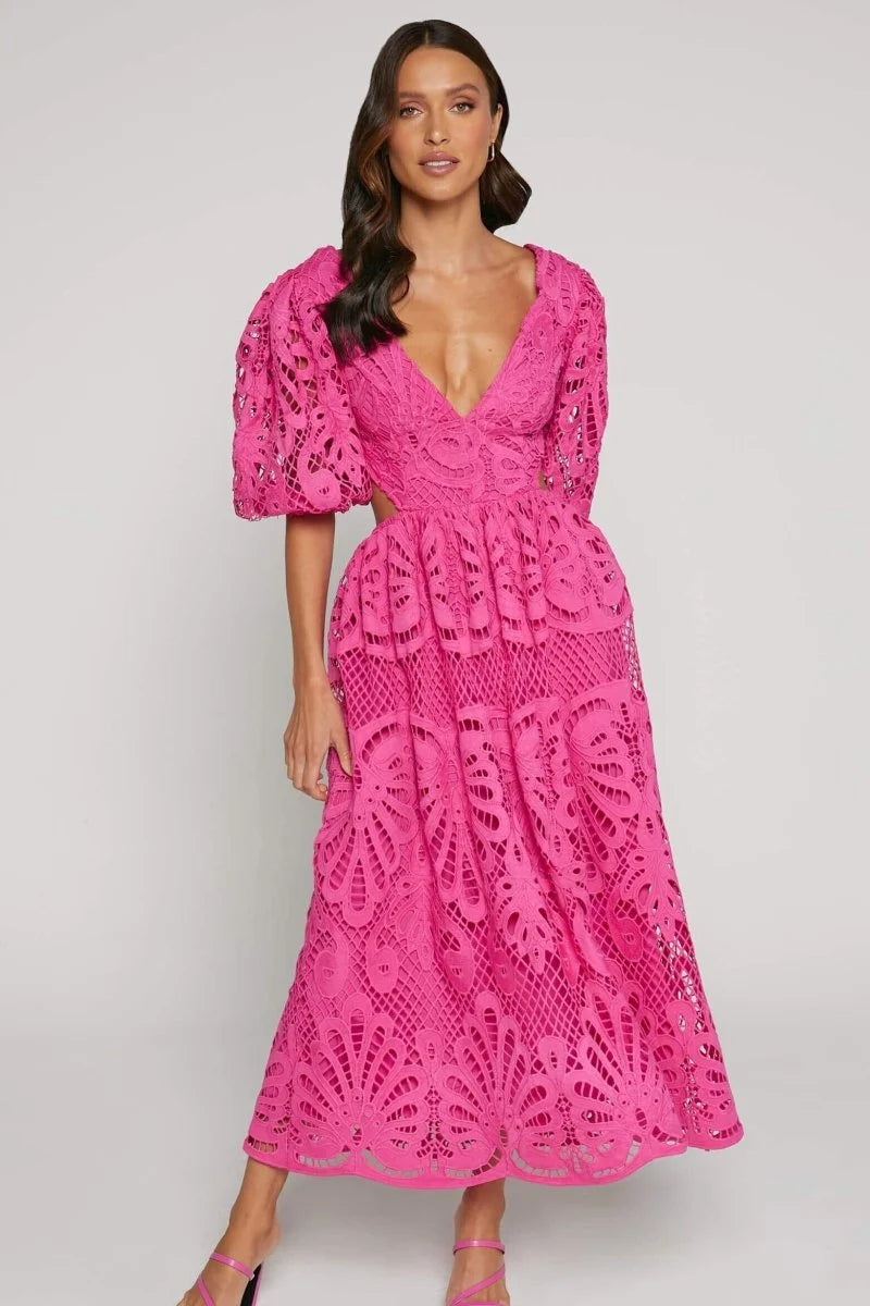 Pink lace dress with V-neckline. Elegant mid-length design with intricate lace detailing.