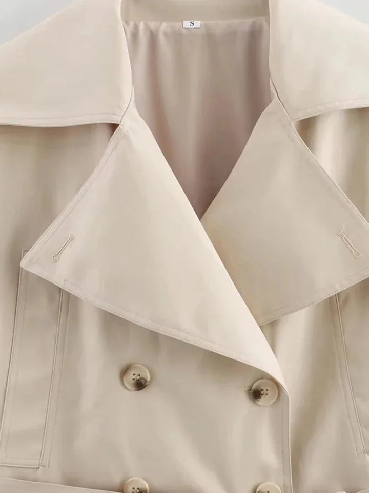"Beige cropped jacket with waist tie, featuring a stylish design. Made from high-quality fabric for a trendy look."