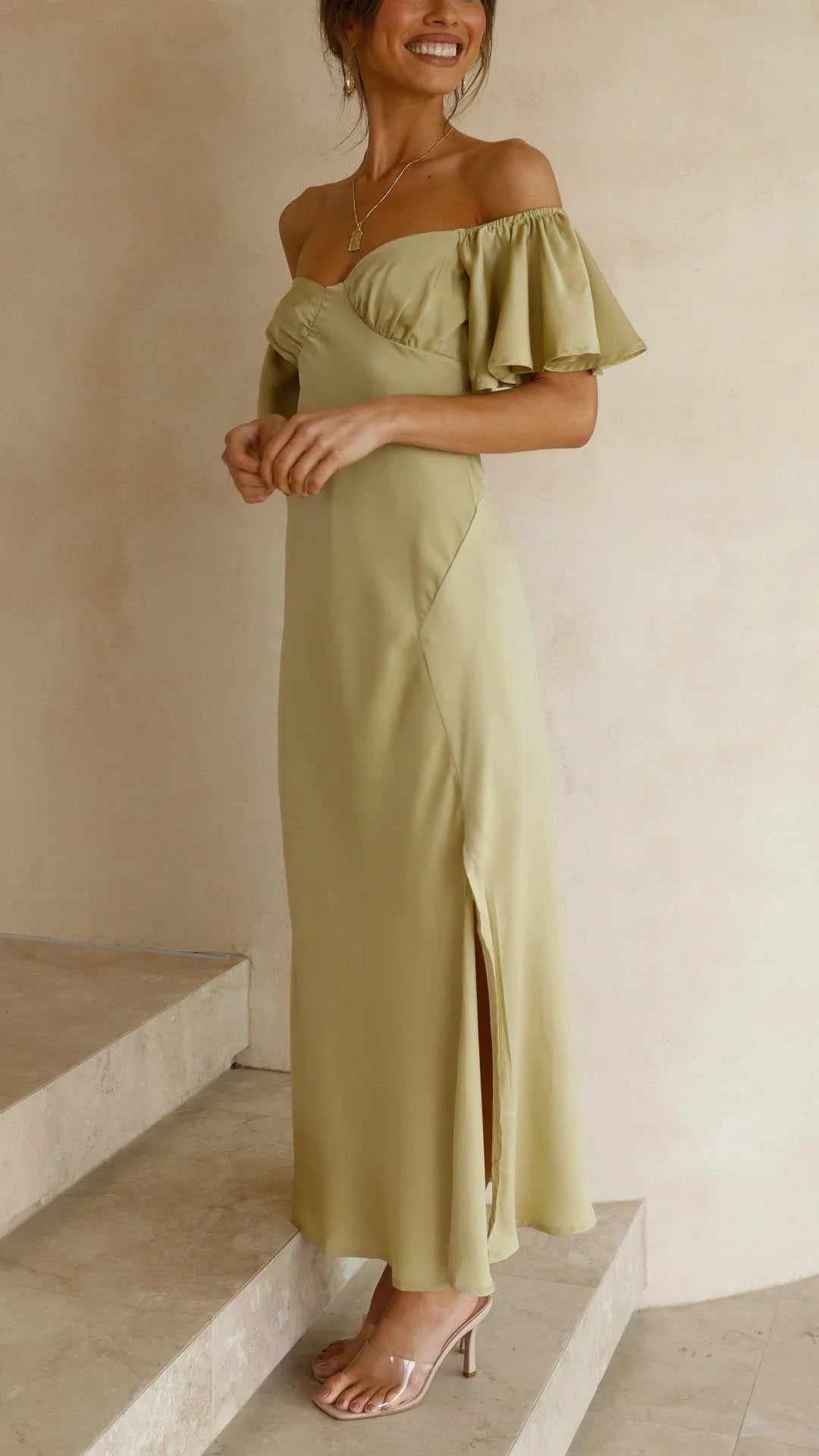 Off-shoulder maxi dress with slits in flowy fabric. Elegant and versatile design perfect for a casual or dressed-up look.