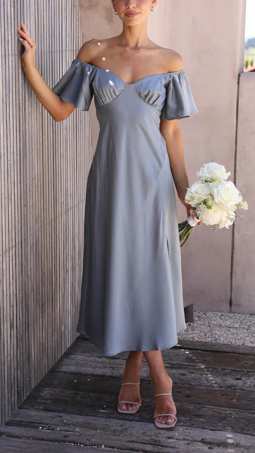 "Blue maxi dress with off-shoulder neckline, flowy silhouette, and slits. Made from lightweight and soft fabric."