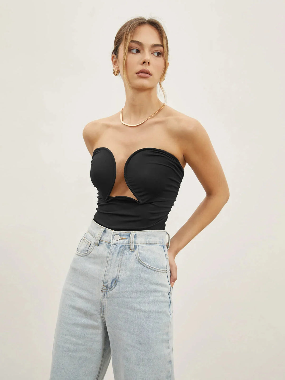 Black strapless top with sweetheart neckline. Made of breathable fabric with a fitted design for a chic and elegant look.