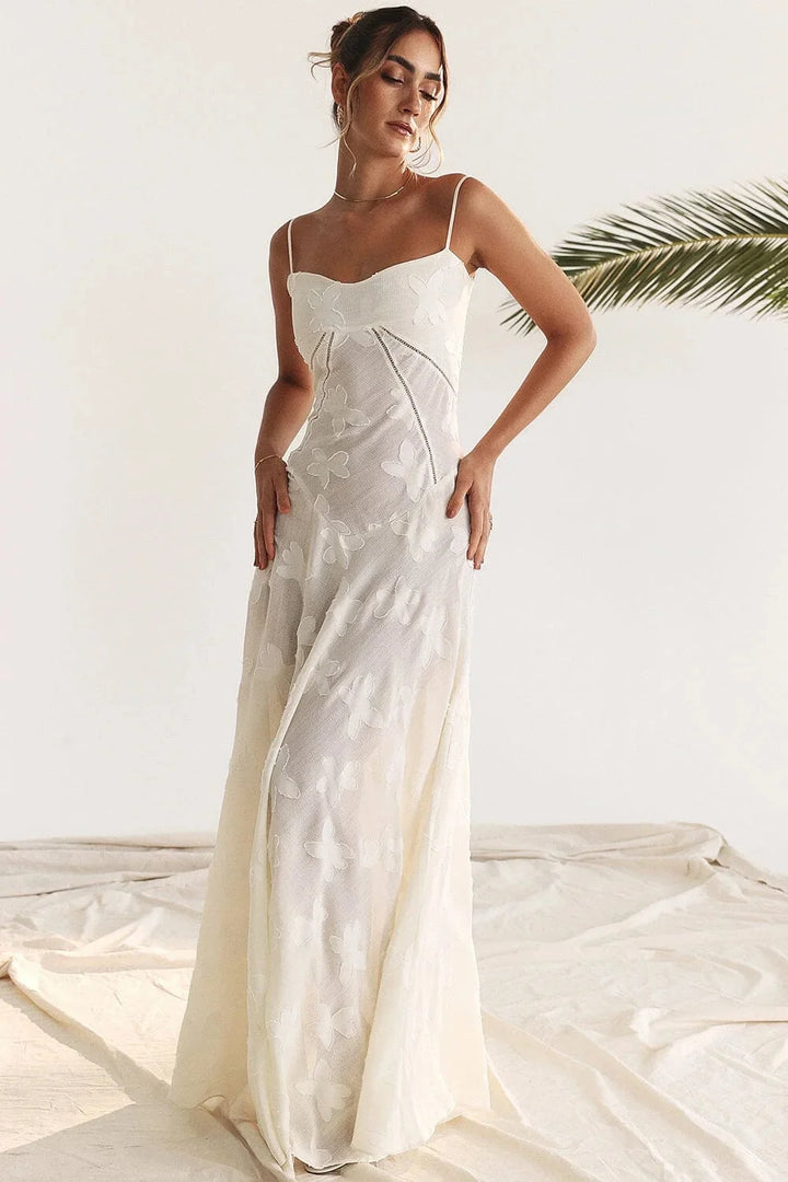 White spaghetti strap maxi dress with floral lace design. Made of delicate lace material for a feminine and elegant look.